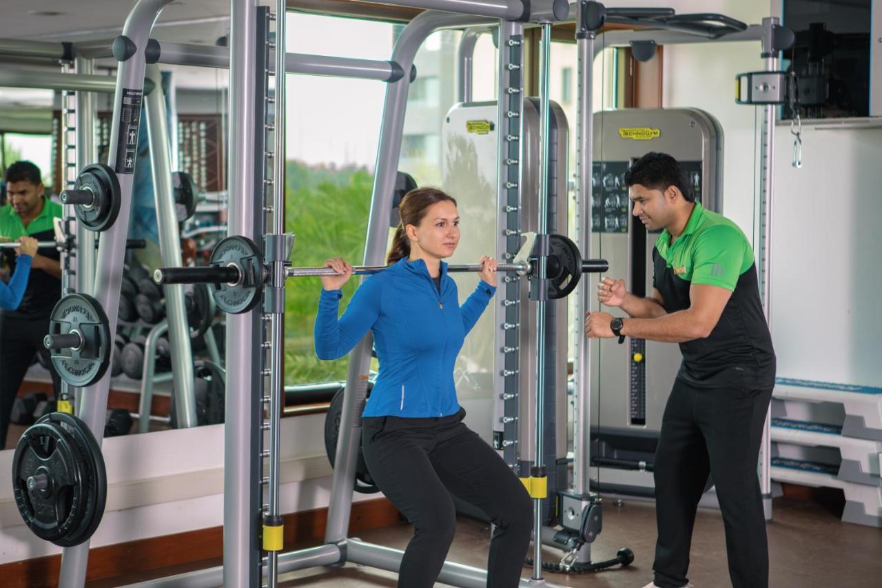 Jumeirah Messilah Beach Kuwait Kuwait City ภายนอก รูปภาพ A personal trainer assisting a woman with a squat