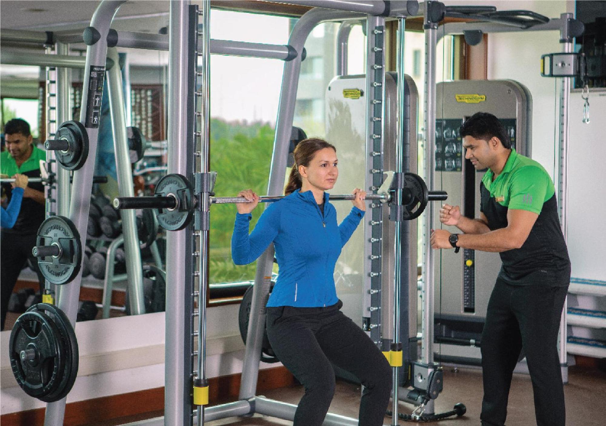 Jumeirah Messilah Beach Kuwait Kuwait City ภายนอก รูปภาพ A personal trainer assisting a woman with a weight training exercise